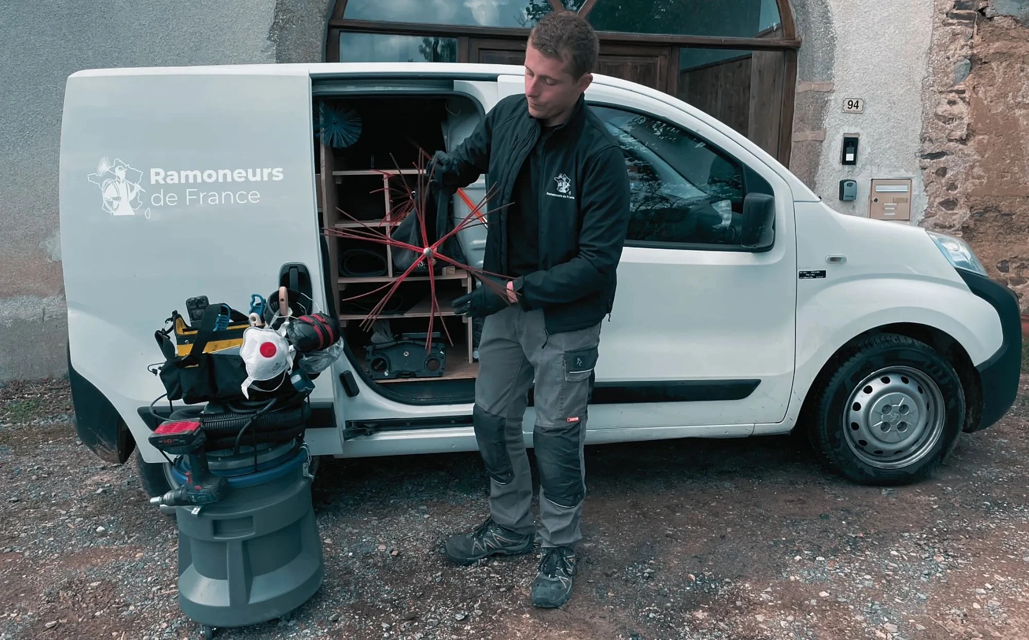 Thomas, ramoneur-fumiste de Ramoneurs de France, préparant son hérisson devant son camion d'intervention